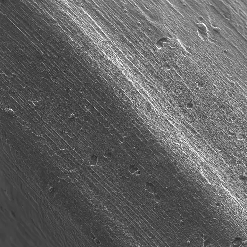 microscopic close-up of machined titanium surface showing fine tool marks and controlled surface finish after CNC milling